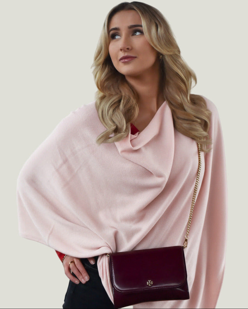 A woman wearing a Powder Pink Cashmere poncho